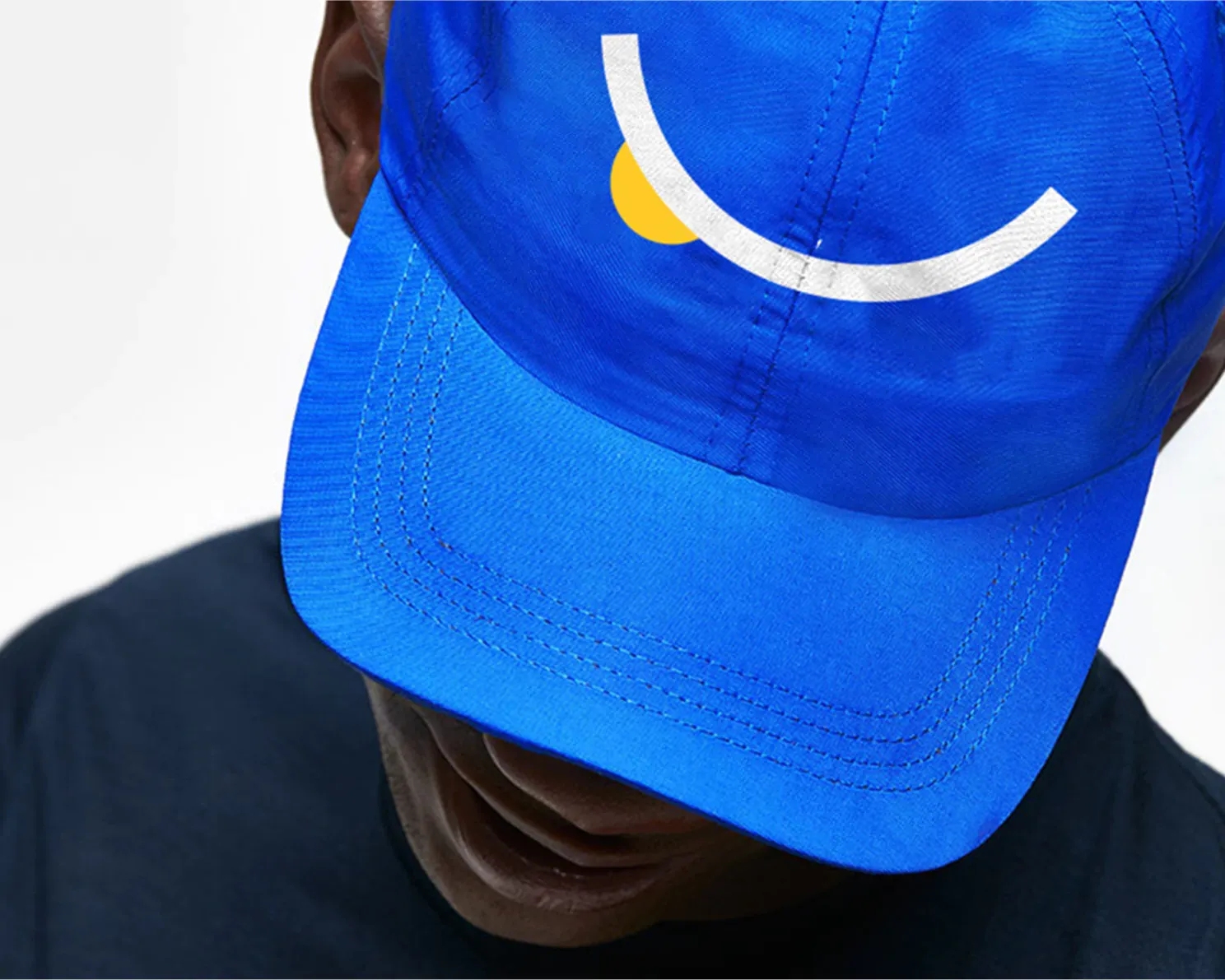 Blue baseball cap with smile graphic on it