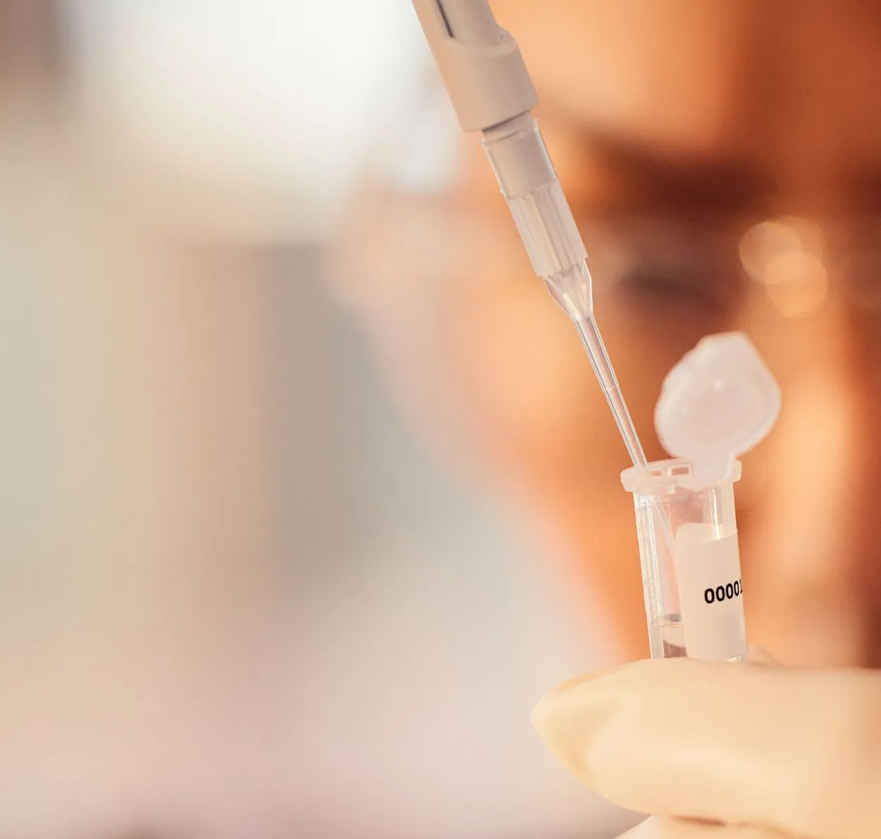 Test tube with woman lab worker in background