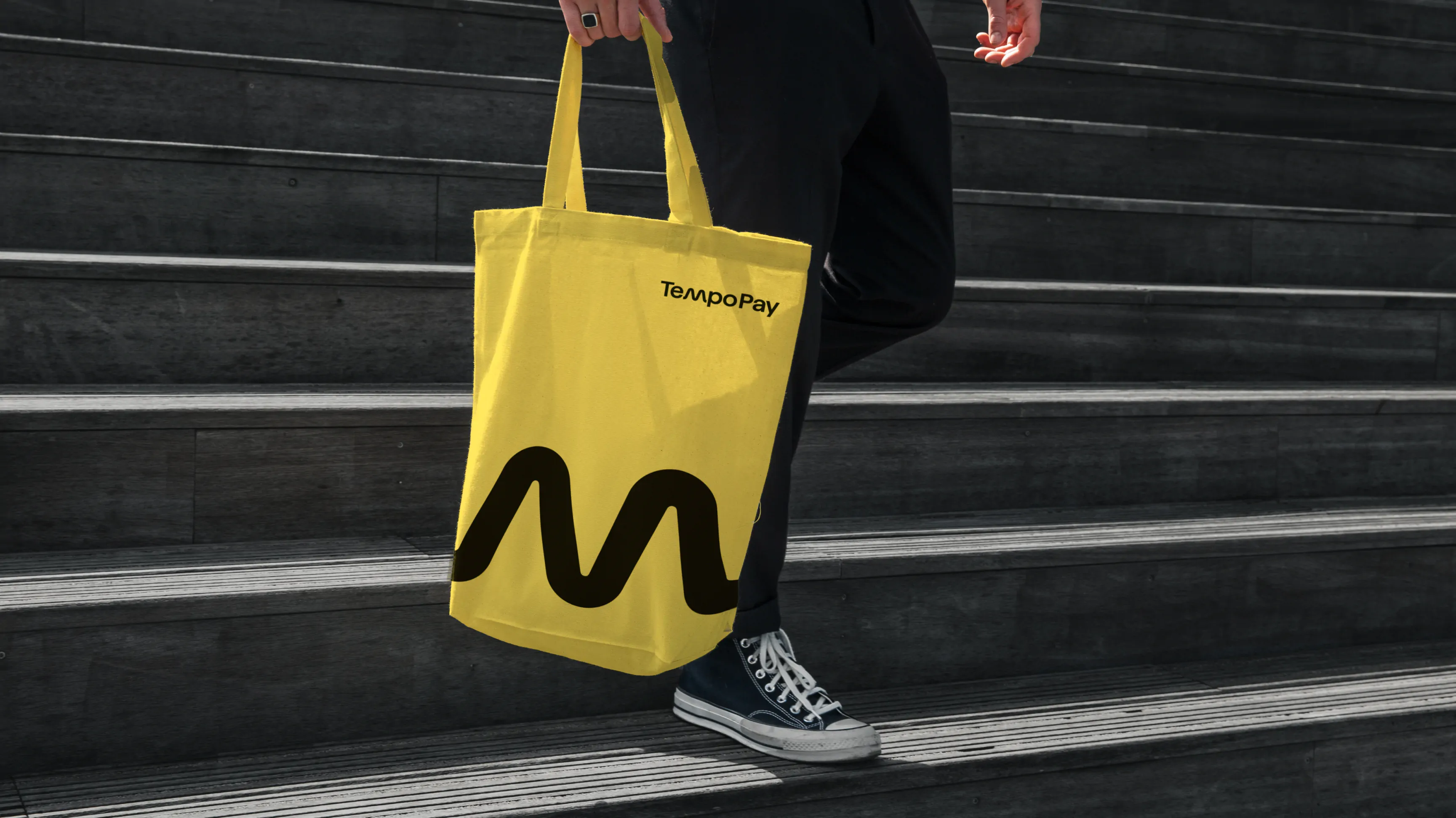 TempoPay tote bag held by a man walking down steps